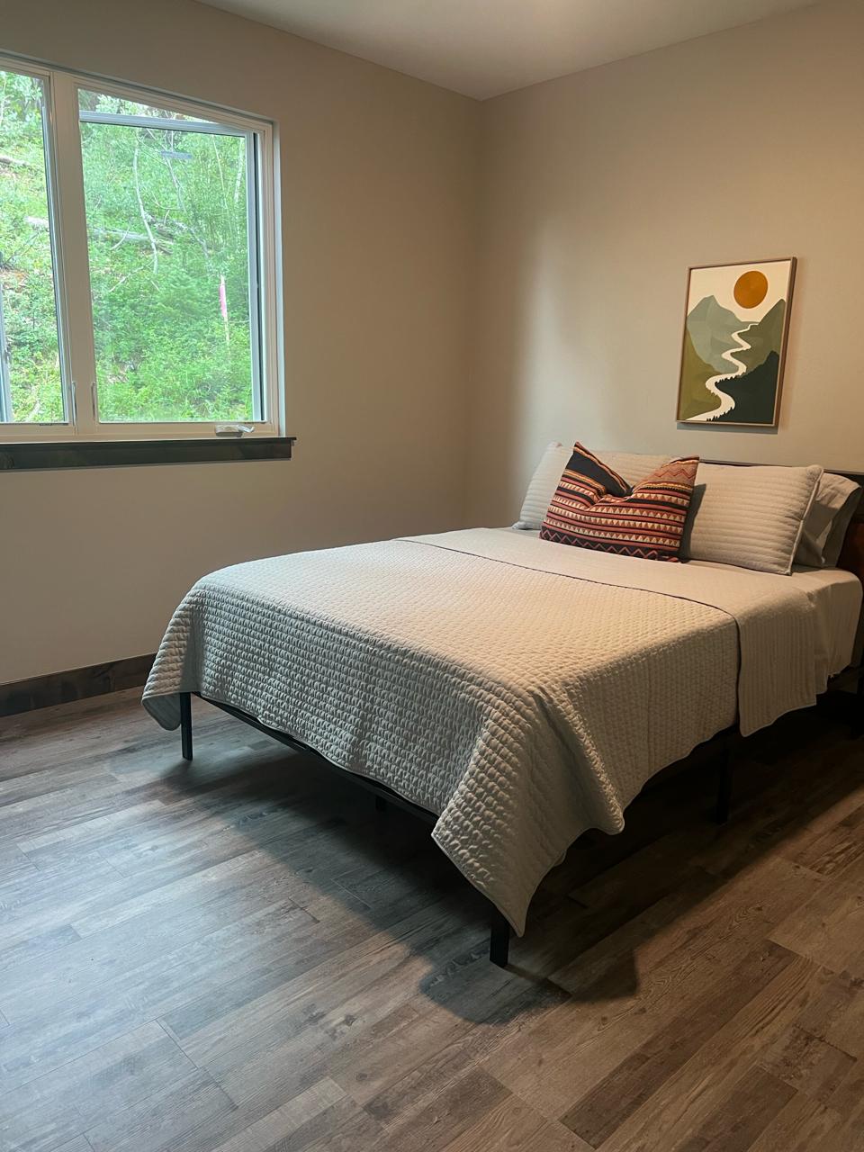 Guest bedroom — green bedding with mountain art